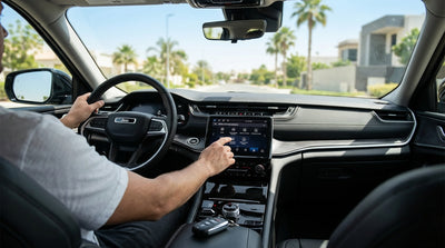 A driver's hand touching the dashboard screen of their United Estates car hire to adjust the vehicle settings