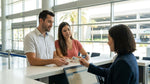 Two friends showing their driver licenses at a car hire counter in Orlando