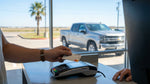 A white SUV car rental driving on a scenic road in West Texas with mountains in the distance