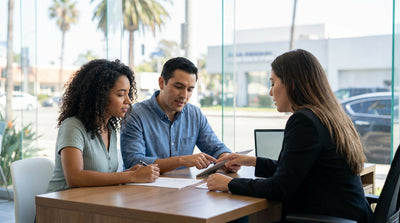 A convertible car rental driving along a sunny, winding coastal highway in California