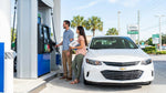 Person checking the dashboard fuel gauge inside a vehicle at an Orlando car rental lot