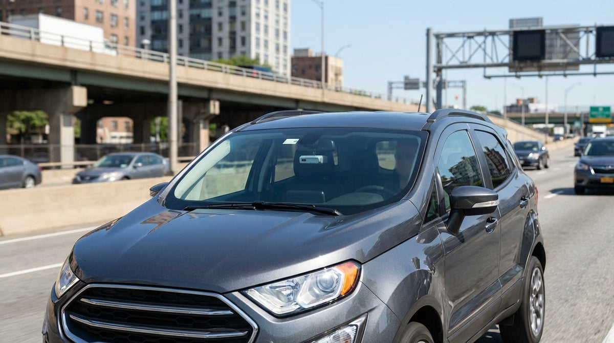 A white car rental driving over a bridge towards the Manhattan skyline in New York