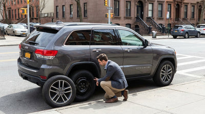 Side view of a car hire parked on a New York street with a small, yellow temporary spare tire