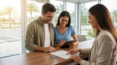 A modern car rental drives down a sunny, palm-lined coastal road in Florida
