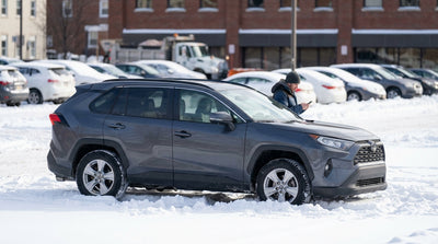 A hire car sits stuck in a snow-covered Pennsylvania parking lot during a winter storm