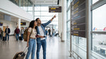 A traveler with luggage walks through a New York airport terminal toward the car rental counters