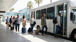 A shuttle bus parked at a Los Angeles airport terminal with a sign for the car rental center