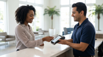 A customer pays with a contactless credit card tap for a car rental pick-up in a modern Florida office.