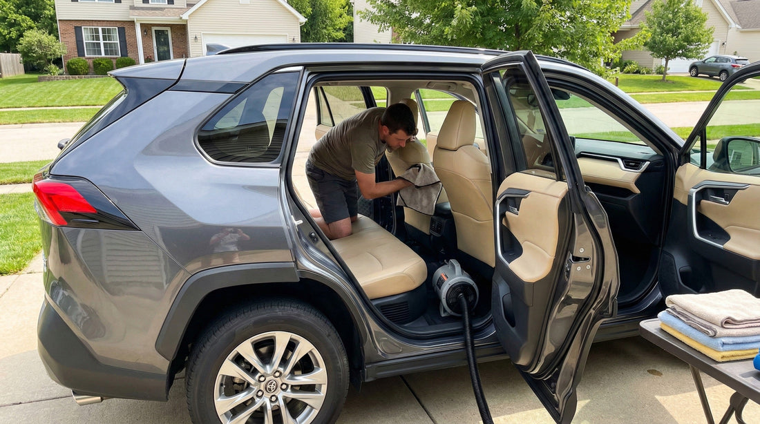 Man using a fan and towels to dry the soaked interior seats of a Florida car hire SUV before returning.