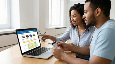 Couple checking Hola Car Rentals prices in the US on a laptop, holding a credit card to easily book their car hire online.