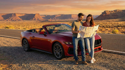 Couple reading a map next to a red convertible on a scenic Route 66 road trip, enjoying their Hola Car Rentals car hire.