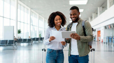 Couple reviewing rental documents and a tablet in the Miami International Airport terminal.