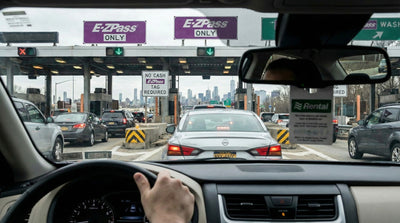 Driver's view approaching an electronic E-ZPass toll booth lane in a New York car hire vehicle.