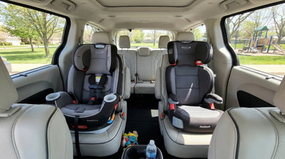 Interior of a rental minivan with installed child car seats showing space for families in Orlando.