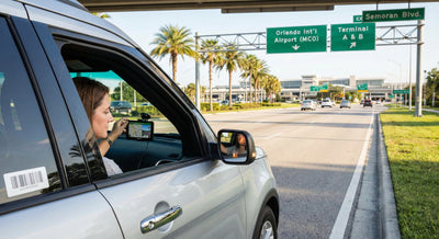 Driver pulling over safely to set up a GPS Sat Nav unit near MCO Airport in an Orlando car hire vehicle.