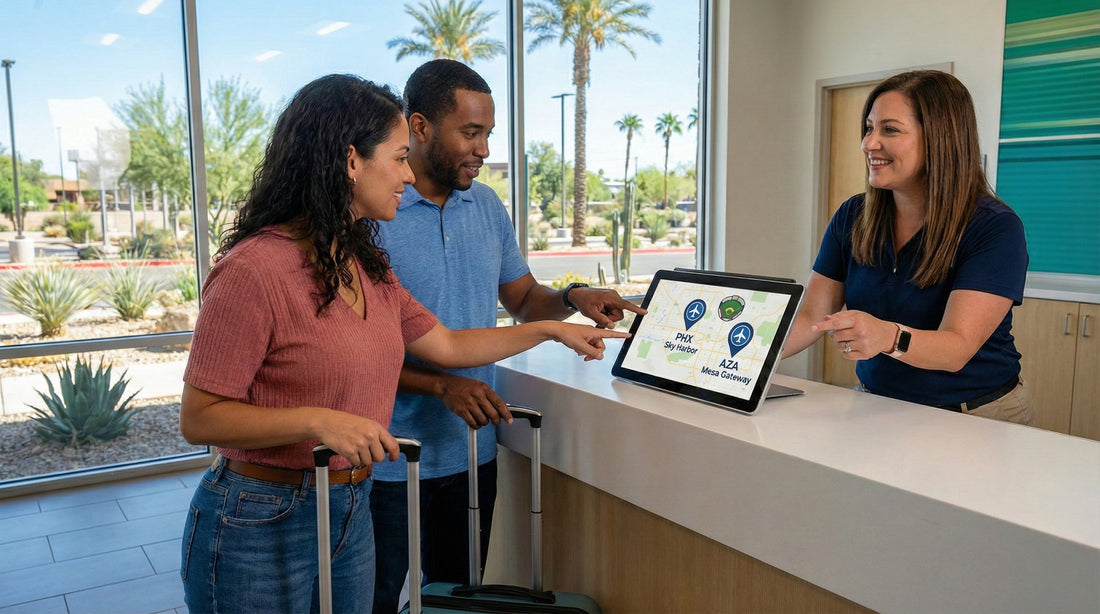 A couple at a sunny car rental counter looking at a tablet map with an agent, with palm trees visible through the window in Phoenix.