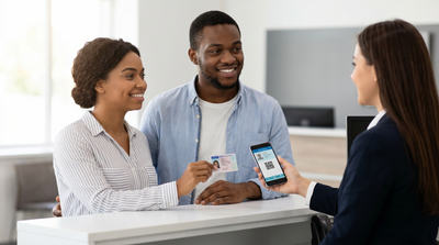 Customer shows both a physical driver's license and a digital phone ID to a car hire agent in Texas.