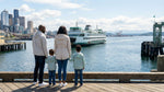 Family looking at a ferry in Seattle while deciding between car rental and public transport.