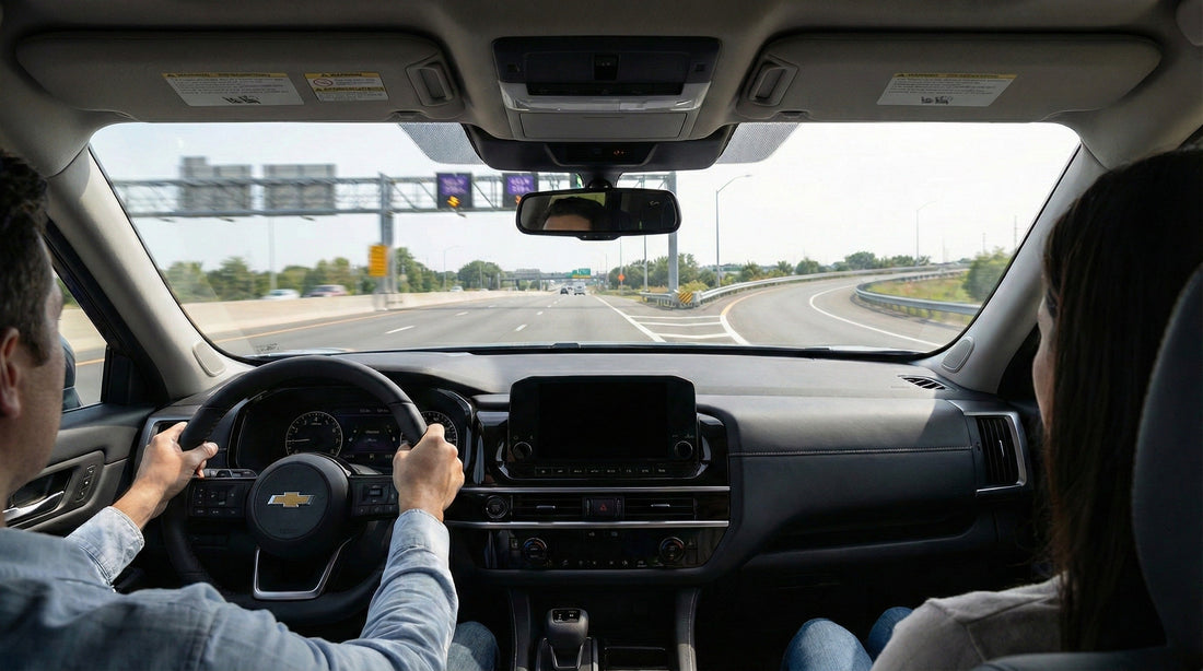 View from inside a modern rental car looking out the windshield at a highway approaching a split, with one side showing overhead toll gantries and the other an open freeway.