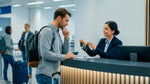 Man at a rental counter considering a vehicle upgrade offered by an agent holding car keys.