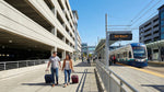 Travelers with luggage walking near the Link light rail station after a convenient car rental return at SEA airport.