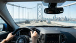 A view from inside a blue rental car driving across the San Francisco Bay Bridge on a sunny day.