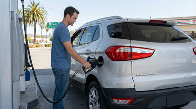 Man refueling a silver SUV at a gas station near San Francisco airport to avoid high prices.