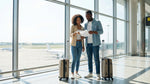 Couple standing in the airport terminal reviewing their car rental agreement documents before picking up their vehicle.